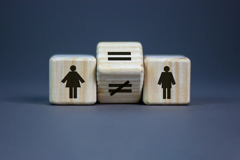 Three blocks bearing figures representing women, men and the "equal" and "not equal" signs