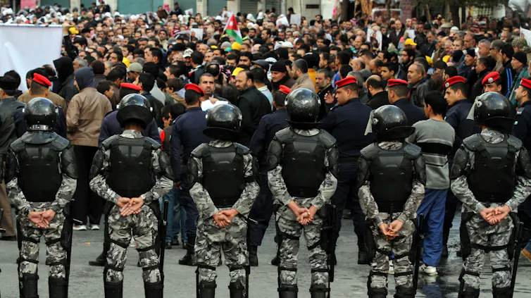 Jordanian security forces surround a demonstration.