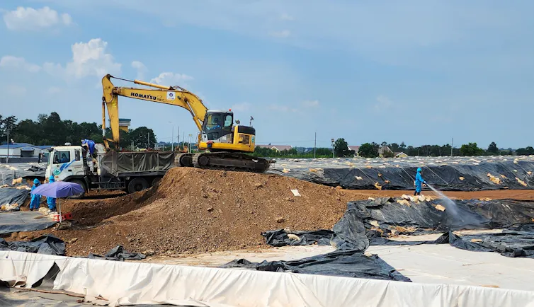 Large equipment move piles of contaminated dirt.