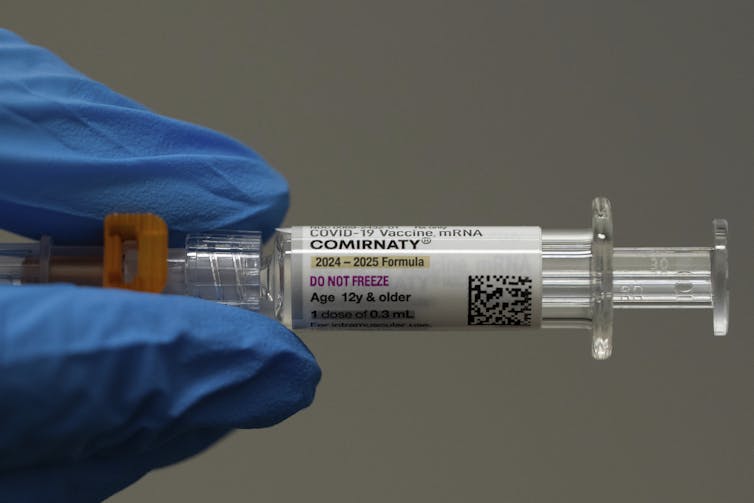 Growy Hand está sosteniendo un disparo de vacunas Covarine-19.