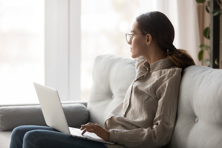 lonely young woman sitting at home with a laptop.