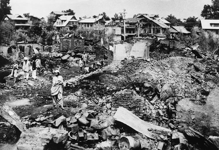 A black and white photo shows rubble.