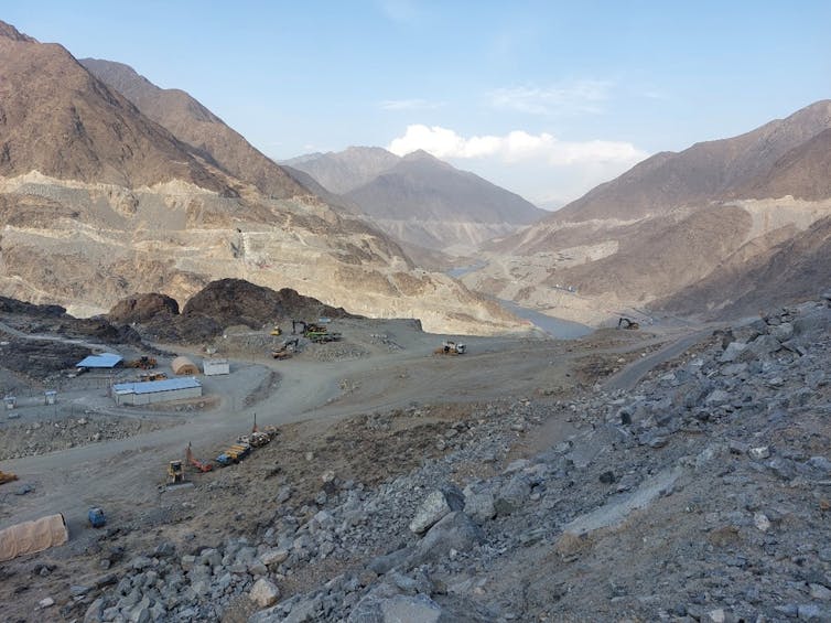 A construction site is seen between mountains