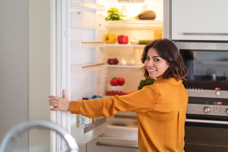 Woman opens fridge
