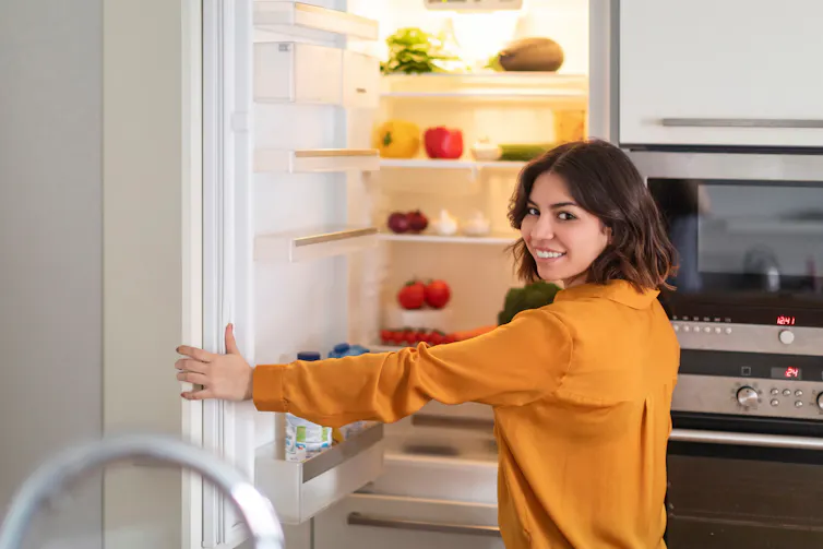 Woman opens fridge