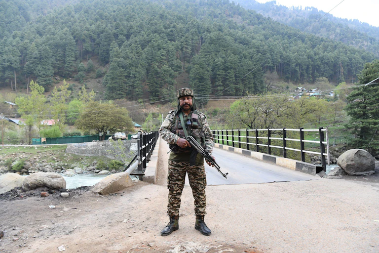 A security guard with a weapon at a spot near where tourists were killed in Kashmir.