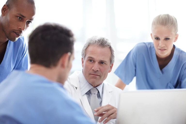 Photo d’un groupe de soignants en train de discuter d’un cas clinique