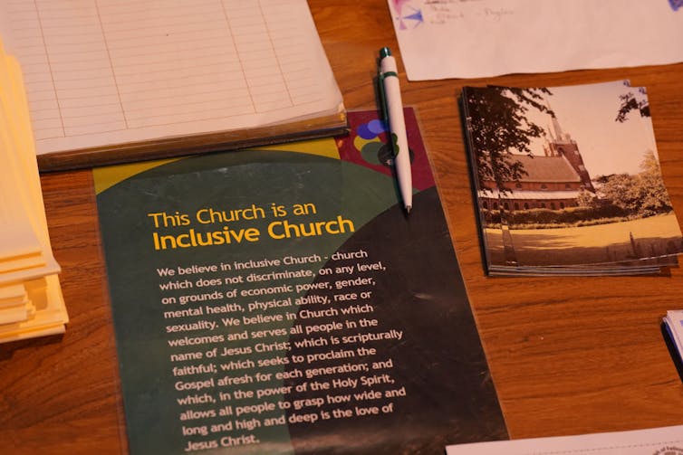 A pamphlet on a table says 'This Church is an Inclusive Church.'