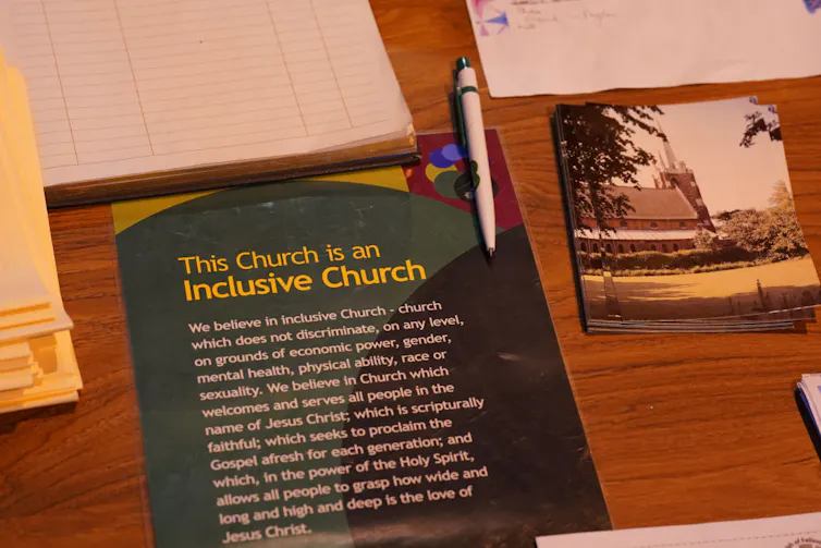 A pamphlet on a table says 'This Church is an Inclusive Church.'