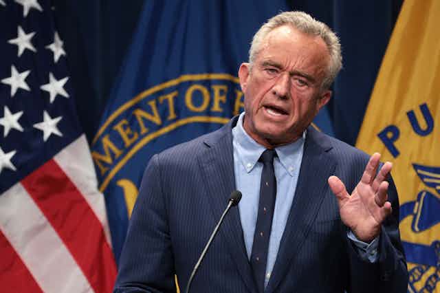 Standing behind a lectern, Robert F. Kennedy Jr. speaks.