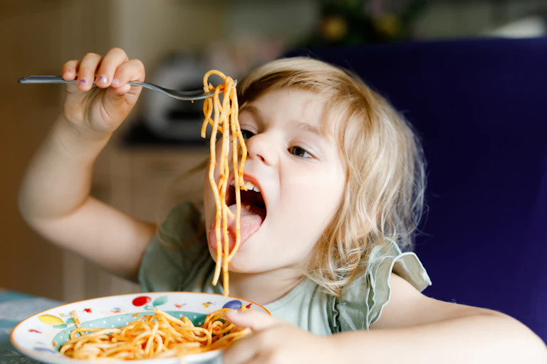 Little girl eating spaghetti bolognese