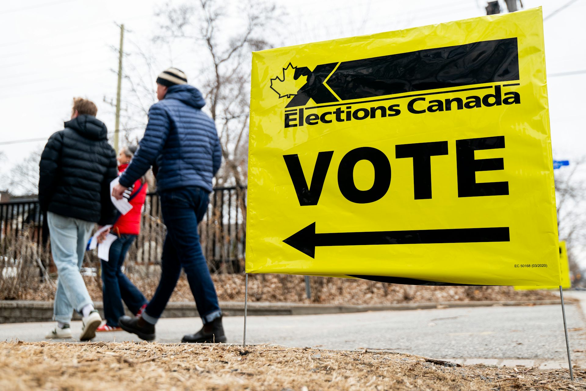 La gente pasa por la votación de las elecciones amarillas brillantes de Canadá