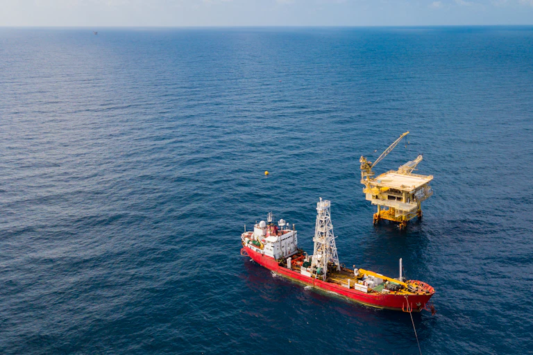 a ship next to an oil platform