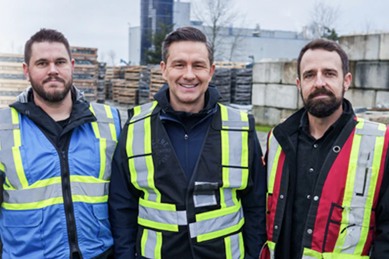 Three dark-haired men in safety vests.