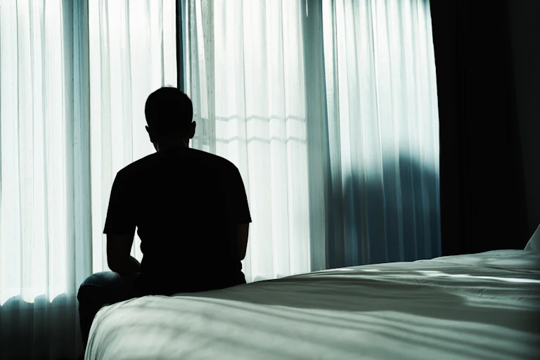 Person sits on their bed