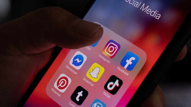 A phone screen displaying icons of multiple social media platforms.