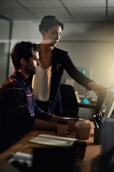 Woman instructing man using a computer
