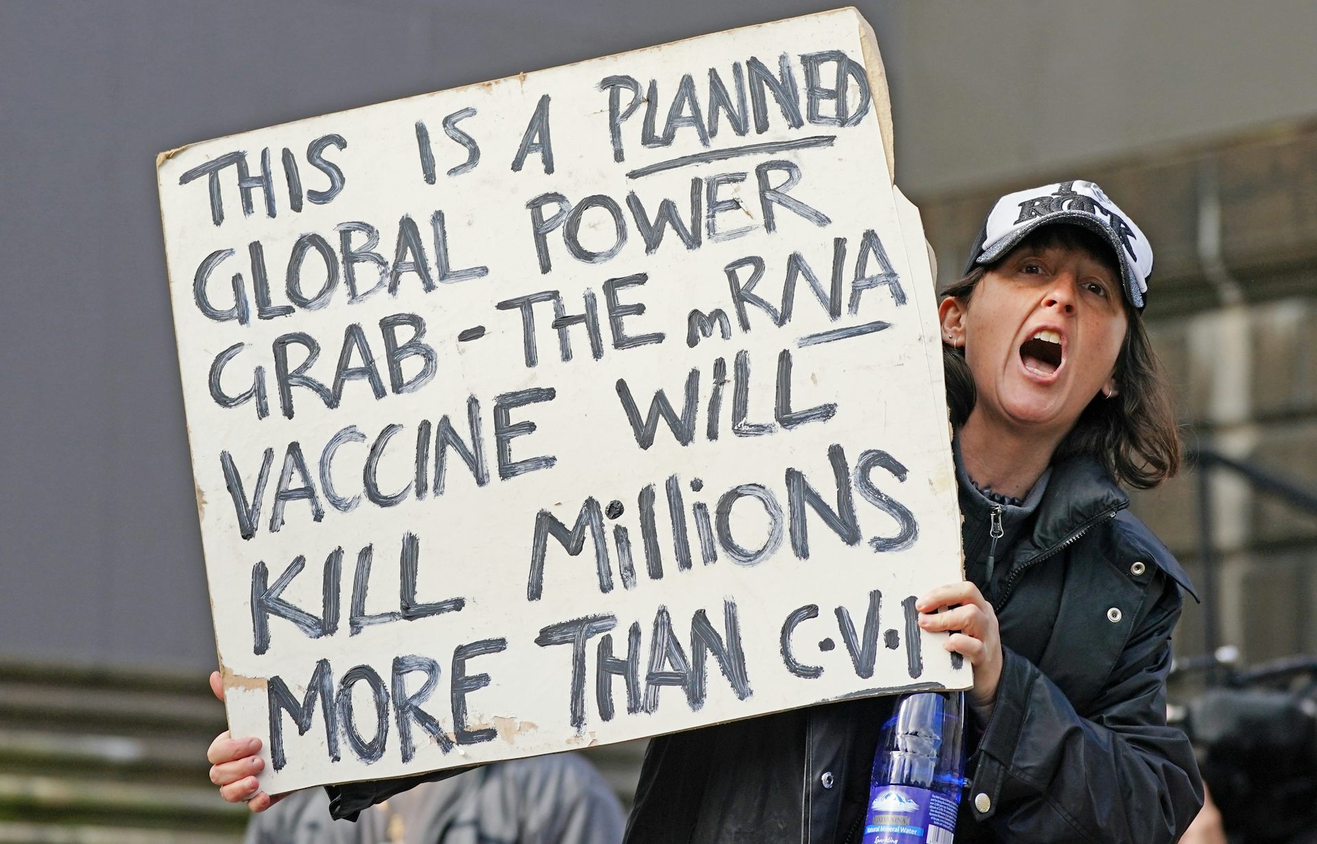 A protestor holds up a sign claiming that mRNA vaccines will 'kill millions'.