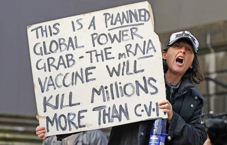 A protestor holds up a sign claiming that mRNA vaccines will 'kill millions'.