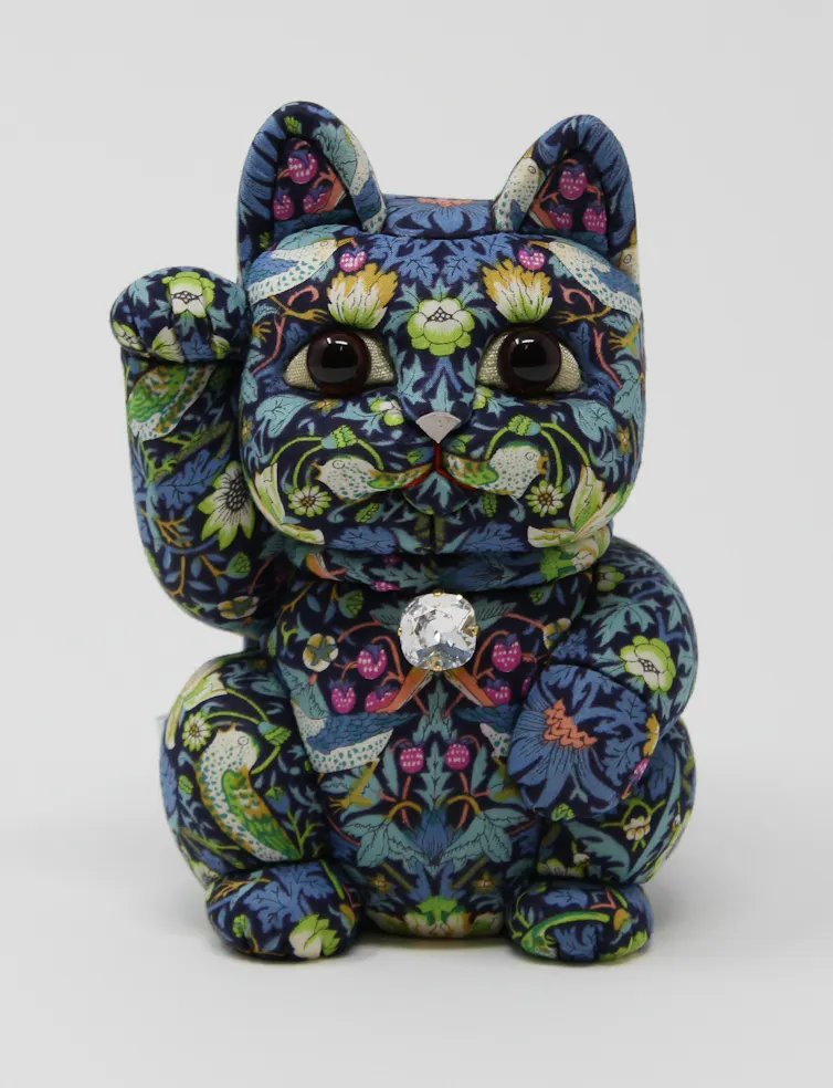 A Japanese waving cat decorated in William Morris's 'strawberry thief' design.