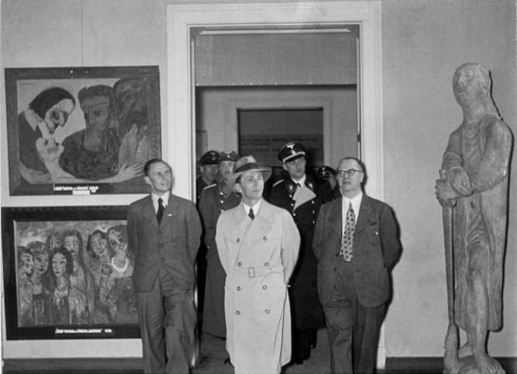 A photograph of Nazi propagandist Joseph Goebbels’ visit to the exhibition titled Entartete Kunst (Degenerate Art) in Munich, 1937. At left, from top, two paintings by Emil Nolde: Christ and the Sinner (1926) and the Wise and the Foolish Virgins (1910), a painting that has disappeared