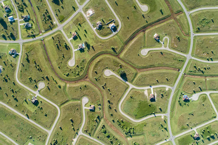 Aerial shot of green area with roads and a low-density housing development