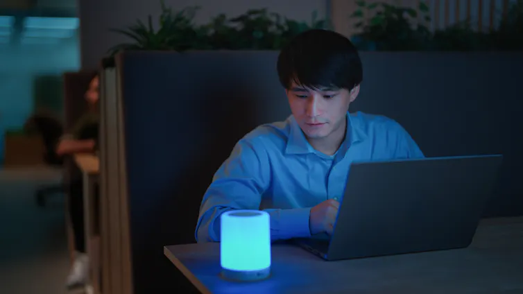 Man in booth at restaurant using computer and smart speaker