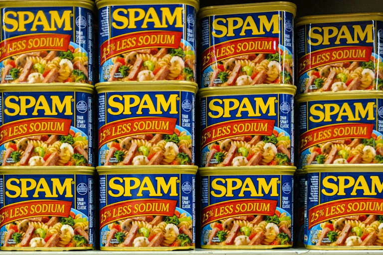 Photo of cans of Spam stacked on a shelf.