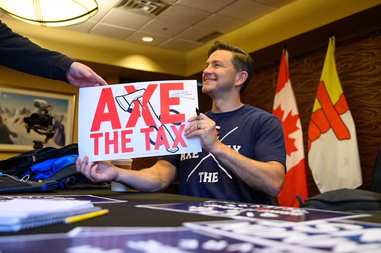 El hombre de cabello oscuro sonrió mientras sostenĆa el plato del signo de impuestos.