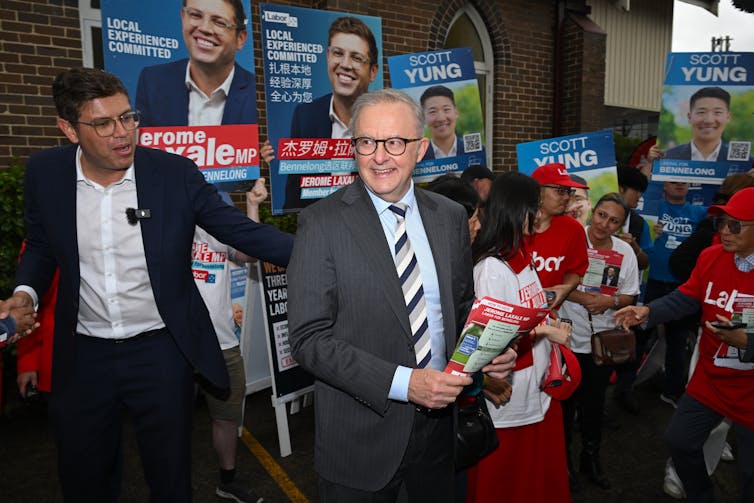 Two men in suits hand out pamphlets at a polling place