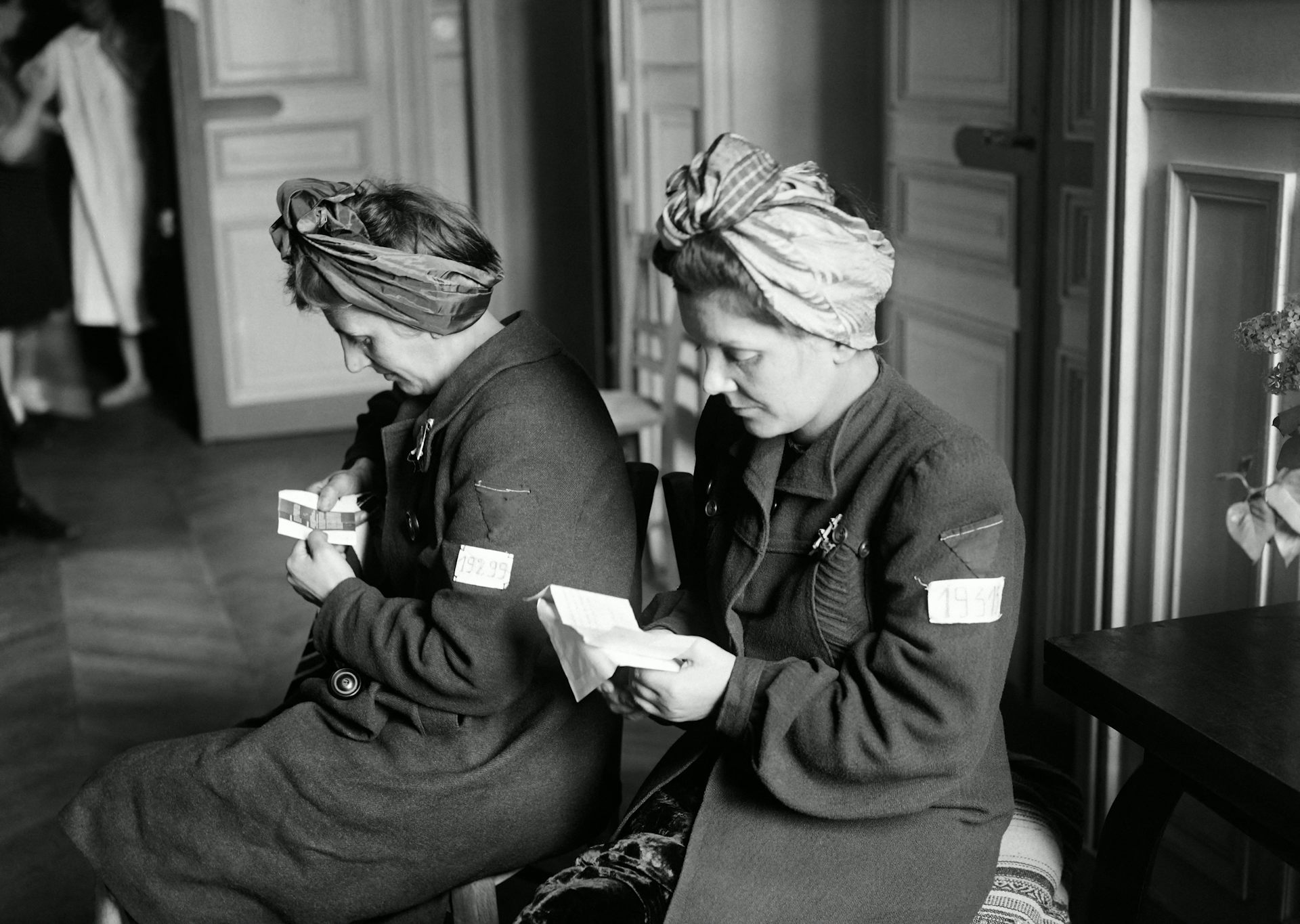 Des survivantes des camps d’extermination, lisent des documents dans un centre d’accueil pour femmes déportées en avril 1945 à Paris, à la fin de la Seconde Guerre mondiale