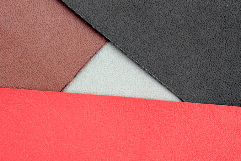 samples of coloured vegan leather, red, brown black on flatlay
