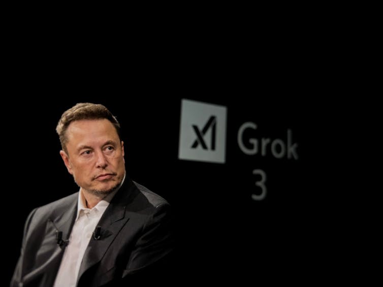 tesla ceo elon musk sitting in front of some grok branding