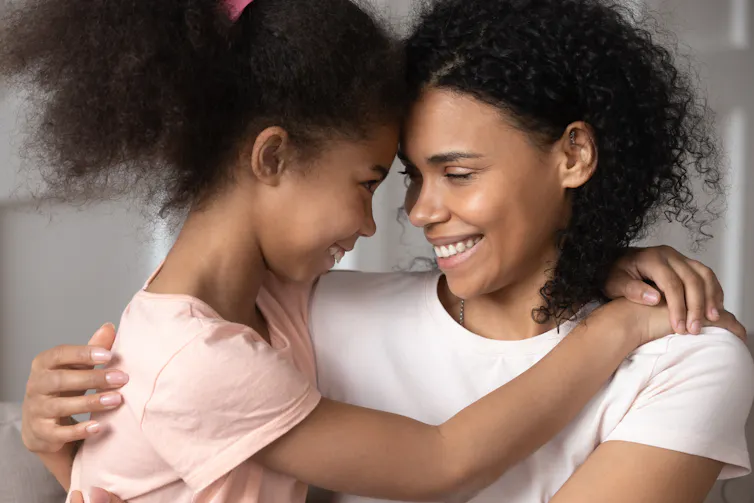 Mother and daughter hugging and smiling