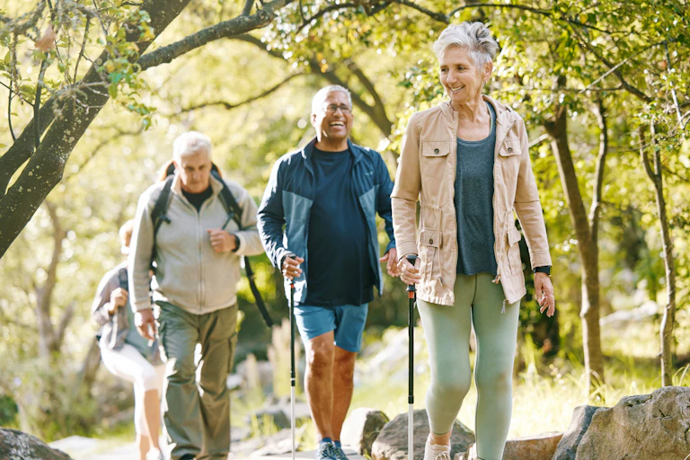 Group of smiling adults hiking through woods