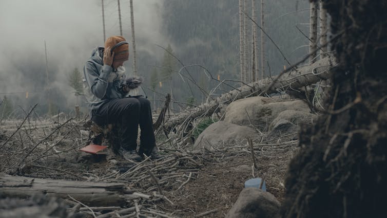 woman with equipment sitting near tree