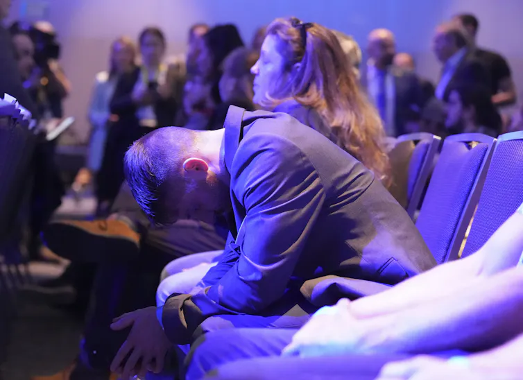 A young man slumps in his seat