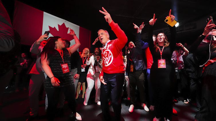 Canadá aún no está profundamente polarizado. Lo que revela una nueva investigación sobre la animosidad partidista 4 Un hombre con un polo rojo canadiense baila entre una multitud de personas sonrientes que también bailan.