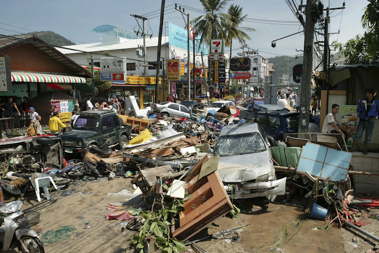 Broken down cars and debris line a street