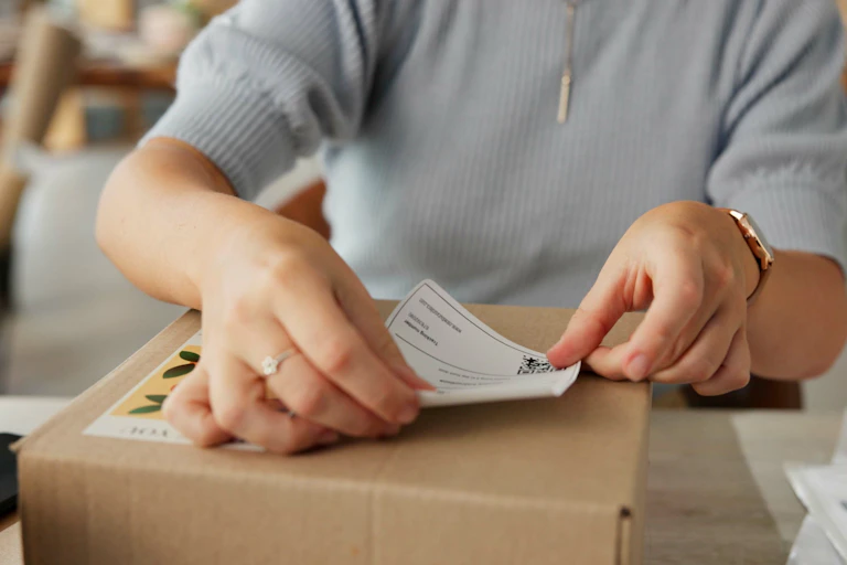 Person places a sticker on a package to be sent