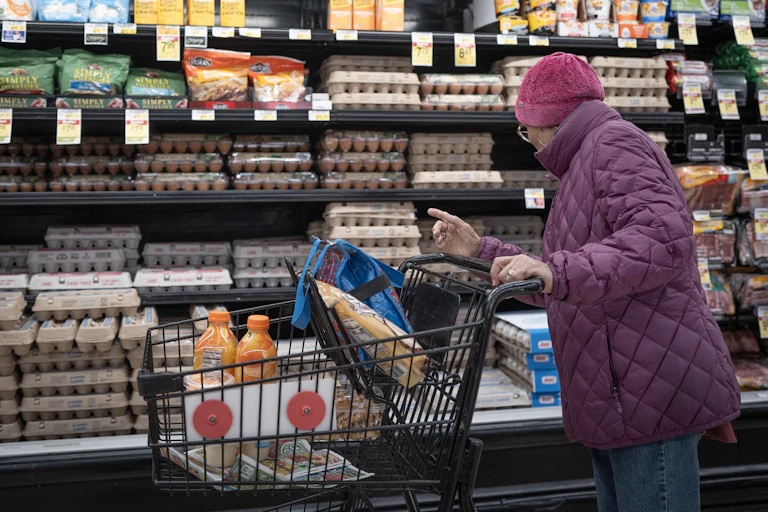 A customer shops for eggs at a grocery store.