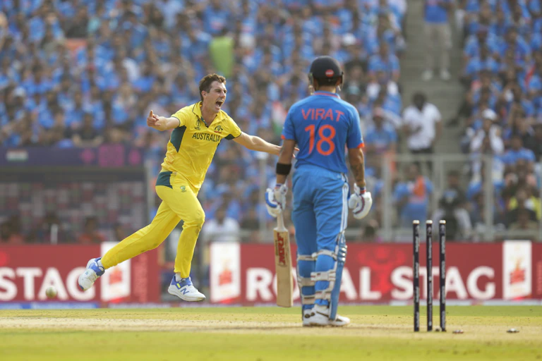 a man in a yellow uniform runs on a field in a crowded stadium with his arms spread and mouth open as another man in a blue uniform stands and watches