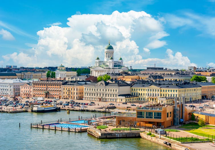 A panoramic view of the centre of Helsinki with blue skies and a white cloud above the white cathedral in the centre.