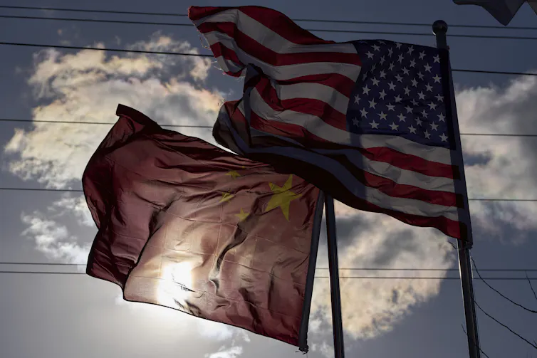 The flags of China and the United States against a blue sky