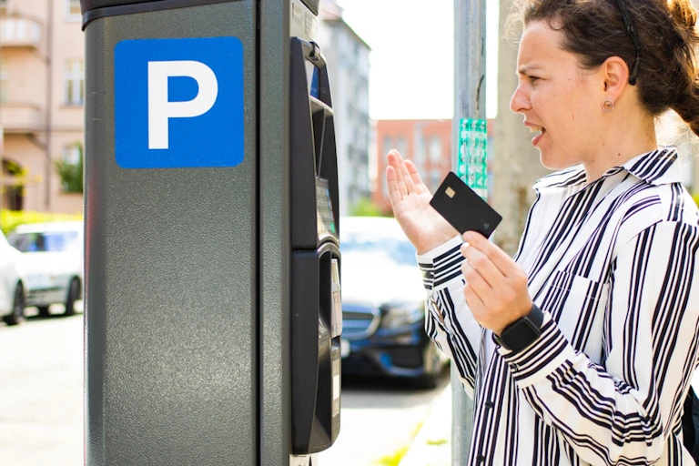 Angry woman paying for street parking with credit card