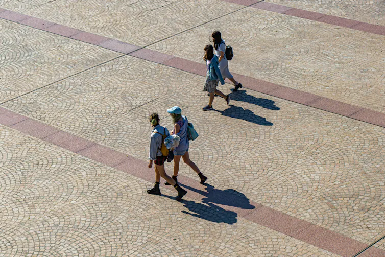 Girls walk across a plaza