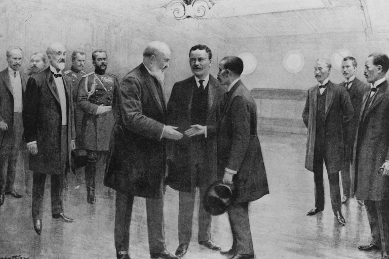 Three men standing and talking amid a group of other men.