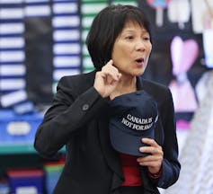 Mujer asiática con bob corto oscuro que Holding Canada no está a la venta Cape