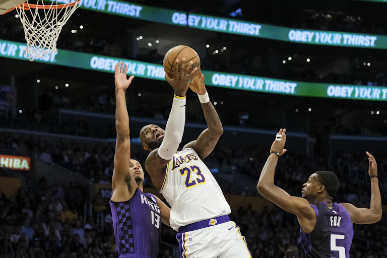 A man is holding a basketball and trying to score a point.