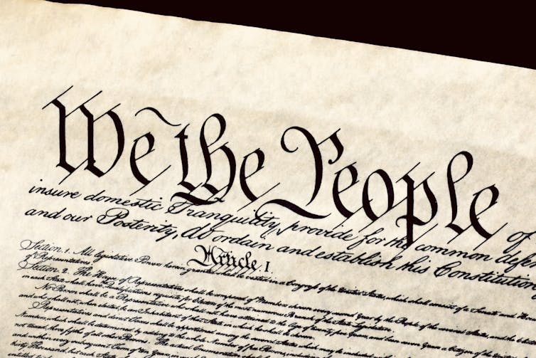 A document written in cursive that begins 'We the People'